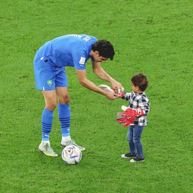 حارس المنتخب المغربي ياسين بونو يحتفل رفقة طفله على أرضية الملعب بعد نهاية المقابلة