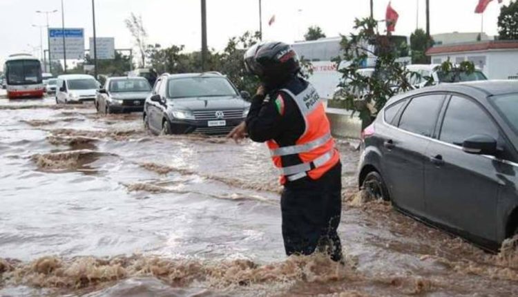 رجل أمن يزاول عمله وسط الأمطار و السيول الغزيرة في الدار البيضاء و يثير الجدل في مواقع التواصل