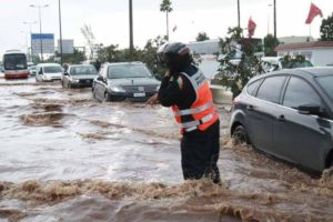 رجل أمن يزاول عمله وسط الأمطار و السيول الغزيرة في الدار البيضاء و يثير الجدل في مواقع التواصل
