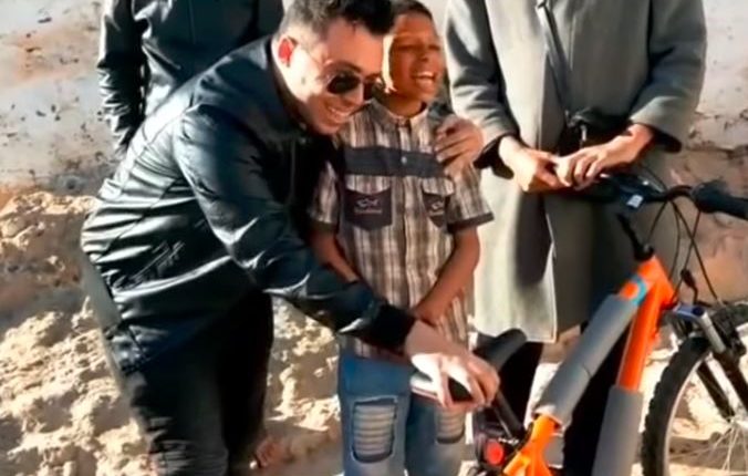 بالفيديو..بعد إثارته الجدل بعبارة "بيكالتي" زكرياء الغافولي يهدي الطفل يونس دراجة هوائية